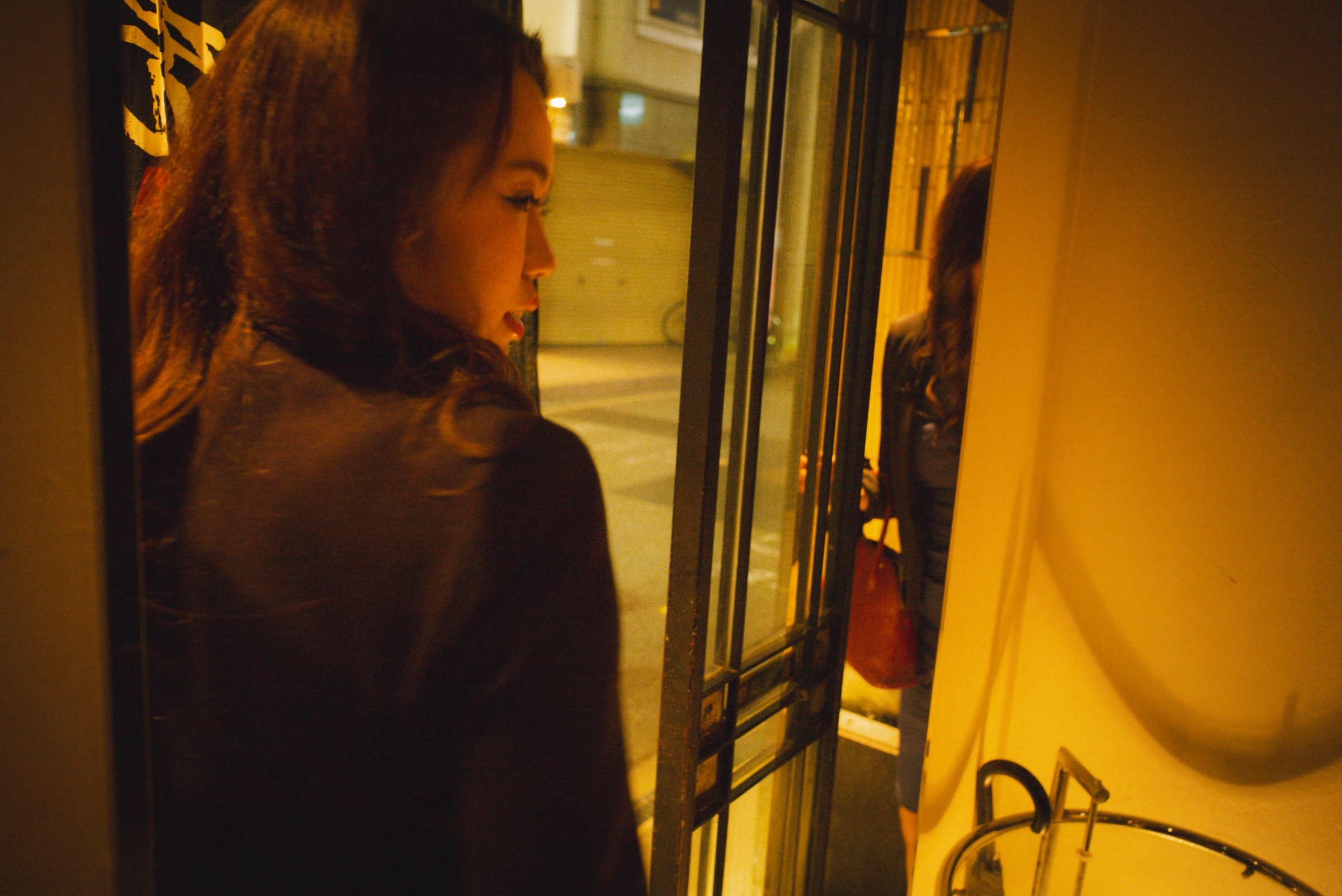 A woman walks out of a restaurant.