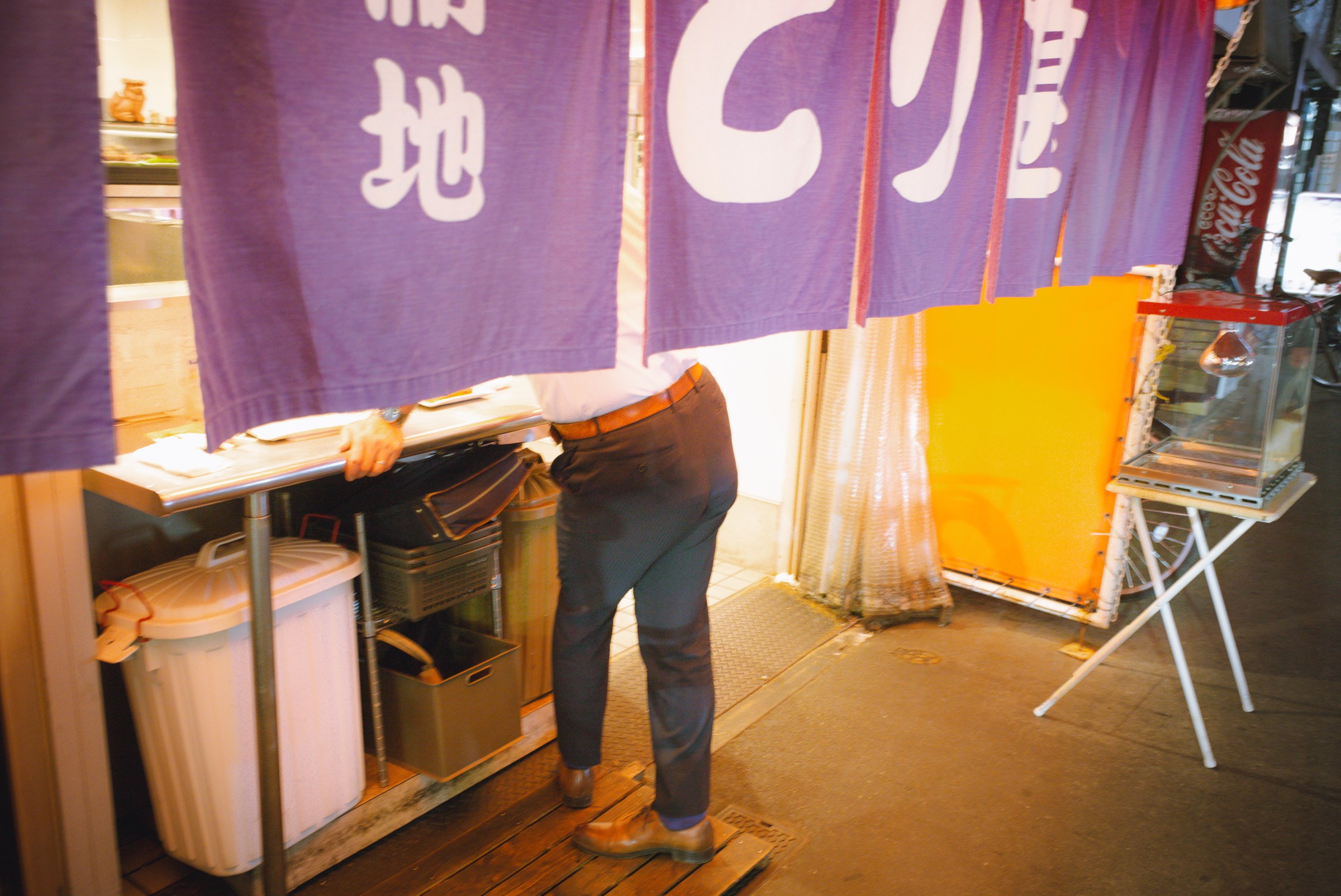 A man drinking at a roadside bar.